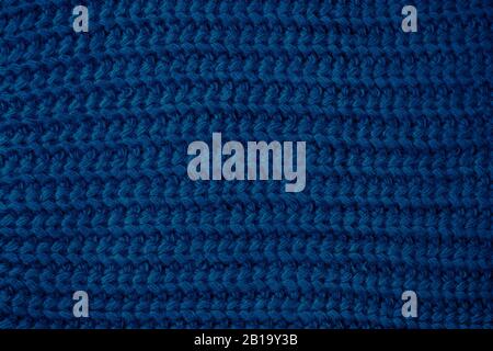 Blue knitted texture, dark fabric background. Color 2020, trends fashion. Woolen sweater, backdrop clothing Stock Photo
