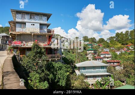 Sagada, Mountain Province, Philippines: Traditional houses in town centre with metal sheets onto walls and corrugated metal roofs Stock Photo