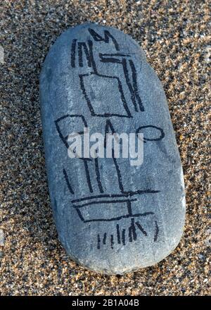 Colour photograph of blue grey coastal stone on beach smoothed and rounded by the passages of time and tide containing stone cobble with grained patte Stock Photo