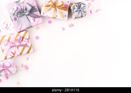 Several gift boxes with bows and confetti on a white background. Stock Photo