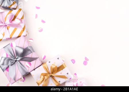 Several gift boxes with bows and confetti on a white background. Stock Photo