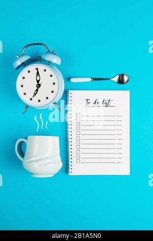 Coffee mug with clock and a To do list on a blue background Stock Photo