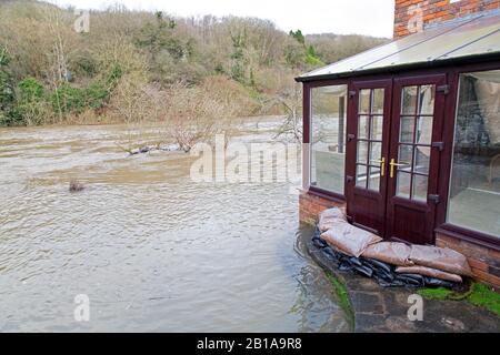 Ironbridge, Shropshire. 24th Feb 2020. UK Weather: The River Severn, having dropped from its flooding levels of last week, is now on the rise again, once again putting homes and businesses in the Ironbridge Gorge at risk. Levels are expected to exceed last weeks heights, and may exceed the record levels of 2000. River expected to peak sometime on Tuesday morning. Credit: Rob Carter/Alamy Live News Stock Photo