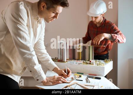 two ambitious achitect discusiing project, sharing ideas, thoughts, development of new neighbourhood. reconstruction. close up photo.architectural, co Stock Photo