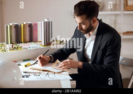 young professional designer using ruler , measuring the drawing, close up side view photo.guy is enthusiastic about a new project, business Stock Photo