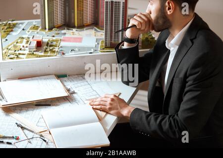 serious man looking at the window, thoughtful , pensive designer looking for inspiration, puzzled man touching his chin and looking aside, close up si Stock Photo