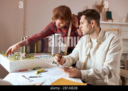 young colleagues creating new ecological neighbourhood, close up side view photo.innovation. 3d model . creativity. team making up original and unique Stock Photo
