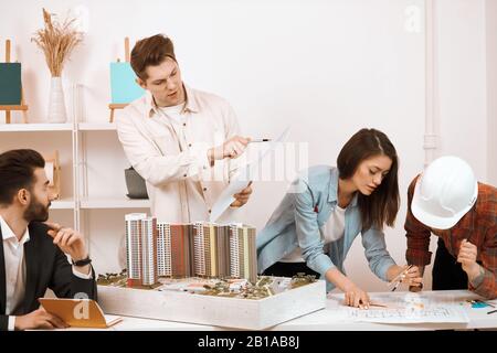 young office workers going to build modern, stylish eco apartments, busy team trying to finish the project, busy working day at the office Stock Photo
