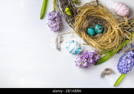 Easter. quail easter eggs in the nest. Hyacinths on white wooden background. with copy space Stock Photo