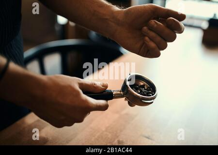 barista puts coffee beans in portafilter, close up side view photo, device concept Stock Photo