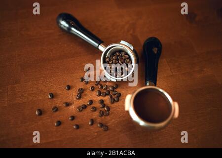 many roasted coffee beans with espresso machine portafilter on wooden table, top view photo Stock Photo