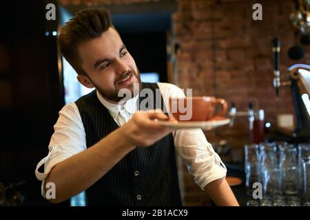 handsome stylish waiter advising wonderful tea for client. close up side view photo. sale, discount , business Stock Photo