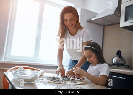 young good looking smiling woman and her adorable child having great time in the kicthen. close up photo Stock Photo