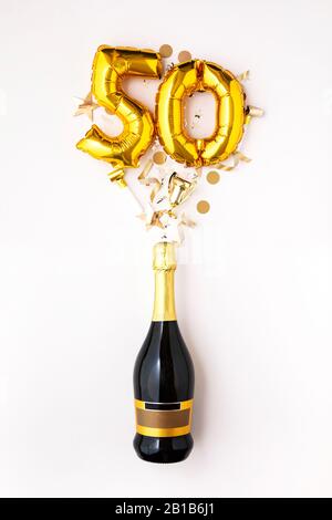 Happy 50th anniversary party. Champagne bottle with gold number balloon. Stock Photo