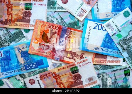 Kazakhstan money banknote on top of russian national currency, top view of mixed roubles. Tenge and rubles exchange rate. Stock Photo