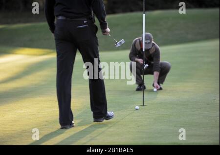 Man marking golf ball on green Stock Photo