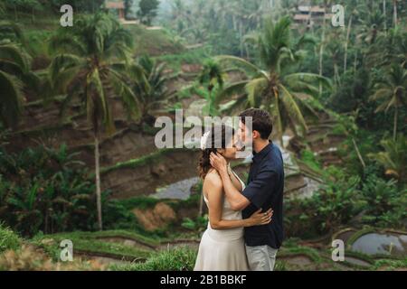 Young latin american couple with amazing view of Ubud rice terraces in morning. Happy together, honeymoon in Bali. Travel lifestyle. Stock Photo