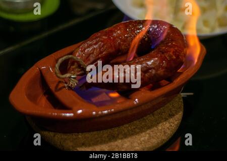 Grilled and simmered chorizon from portugal with aguardiente Stock Photo