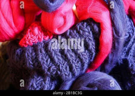 Closeup of knitted colorful purple pink blanket, ball of merino wool, knitting needles Stock Photo