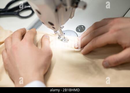 Hands of male tailor on sewing machine Stock Photo