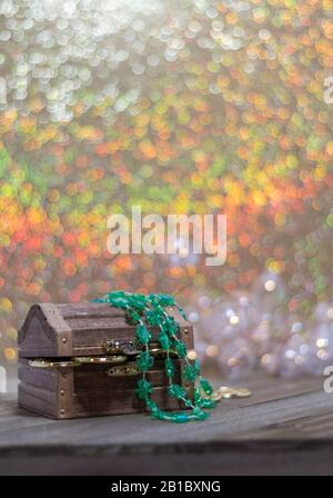 Wooden treasure chest with gold coins for St. Patricks Day on wooden board soft warm color bokeh room for text portrait Stock Photo