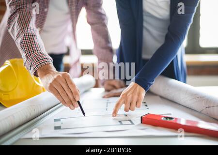 Architects working with blueprints in the office. Teamwork architects concept. Stock Photo