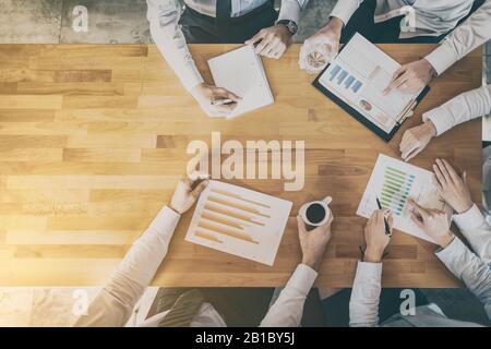 Business team analyzing financial documents or working on startup project. Teamwork and meeting concept. Stock Photo