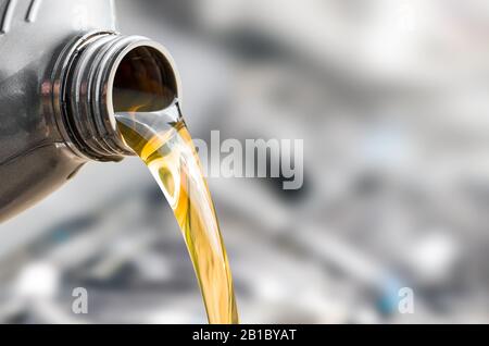 Pouring oil to car engine. Fresh oil poured during an oil change to a car. Stock Photo