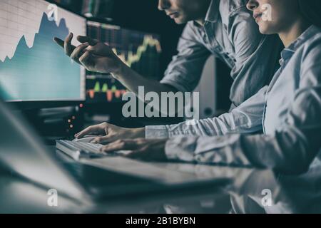 Analyzing data, graphs and reports for investment purposes. Creative teamwork traders. Stock Photo