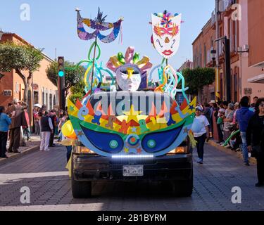 Decorated Float with word Carnaval in the kids parade of the Tlaxcala Carnival featuring Litters of Huehues in traditional Mexican costumes. Stock Photo