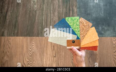 man selects the color decor new floors of different colored sample in a furniture store and floors Stock Photo