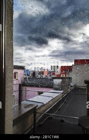 Gloomy view from window over city roofs in the rain, urban landscape Stock Photo