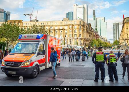 FRANKFURT, GERMANY - AUGUST 31, 2018: Central square crowded with people, emergency mobile car, skyscrapers of modern architecture, cityscape in sunse Stock Photo