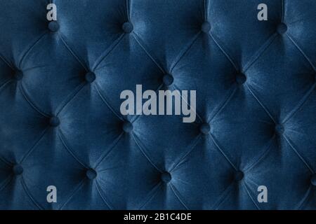 Quilted velour buttoned classic blue color fabric wall pattern background. Elegant vintage luxury sofa upholstery. Interior plush backdrop Stock Photo