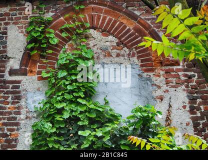 old brick wall with a closed window on old stone house Stock Photo