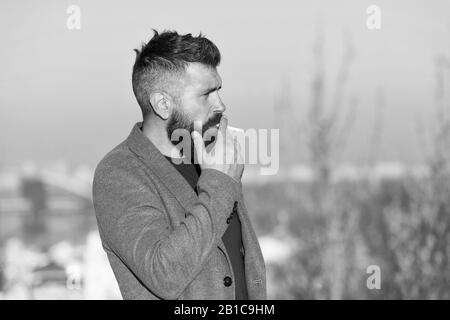 Cigarette tobacco harmful health influence. Smoking aesthetics. Smoking  devices concept. Bearded hipster smoking outdoors. Device hide conceal smell  of smoke. Handsome man smoke flying out of mouth Stock Photo