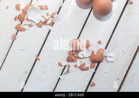 Brown egg shells on wood. Eggshell after cleaning. Stock Photo