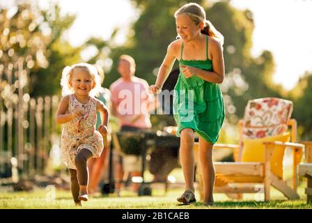 Happy siblings playing in their backyard. Stock Photo
