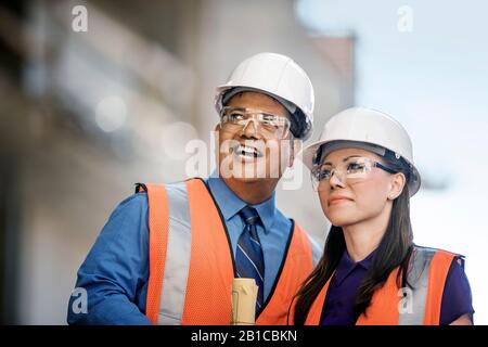 Workers at construction site discuss progress. Stock Photo