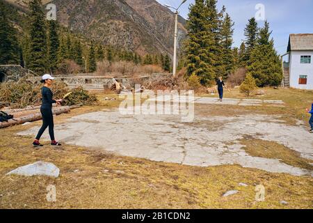 Bishkek, Kyrgyzstan -April 9, 2019: International mointain day. Tourists play badminton before Hiking in the mountains. Stock Photo