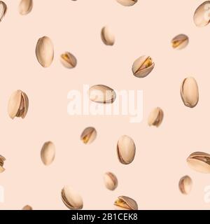 Seamless pattern with falling pistachio nuts on beige background. Levity kernels. Stock Photo