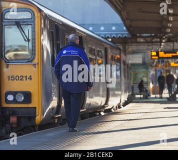 Arriva Northern rail traincrew next to a class 150 sprinter train at Sheffield railway station with the Arriva Northern logo on his jacket Stock Photo