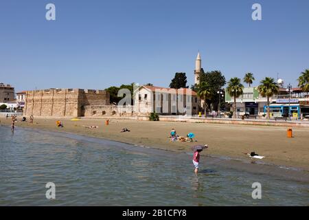 Tourists on the beach by the fort, Finikoudes, Larnaca. Cyprus. 2019 Stock Photo