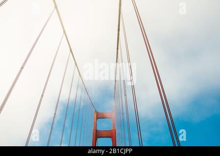 Close up of single tower of Golden Gate Bridge in white clouds San Francisco, USA, bottom view Stock Photo