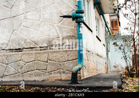 blue old natural gas pipeline installed regularly on the walls of old houses Stock Photo