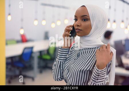Beautiful african corporate worker talking on mobile phone. Happy african american career woman using cell phone Stock Photo