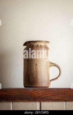 Italian ceramic pitcher on a wooden shelf Stock Photo