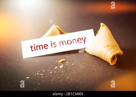 Broken fortune cookie with message TIME IS MONEY Stock Photo