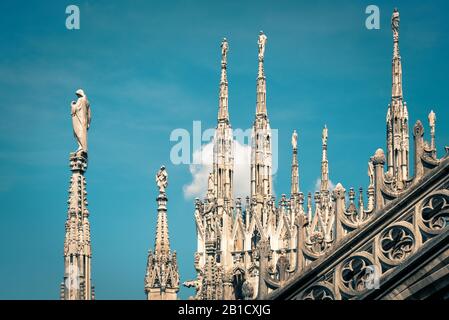 Beautiful view of the Milan Cathedral roof (Duomo di Milano) in Milan, Italy.  Amazing gothic pinnacles with statues at the top of Milan Cathedral on Stock Photo