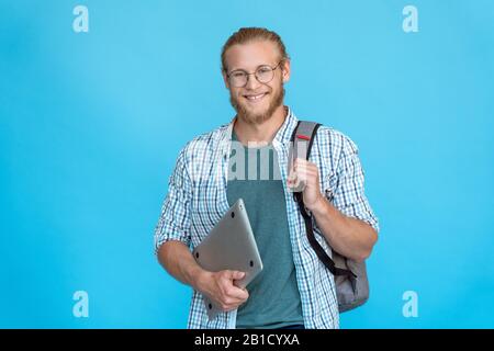 Smiling young bearded college student wear glasses hold modern laptop copy space Stock Photo